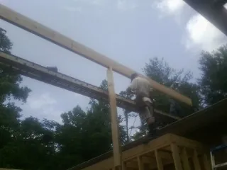 Carpenter setting a ridge beam over a new addition frame — Ice Dam Removal by Roofing Brothers in Jamesville