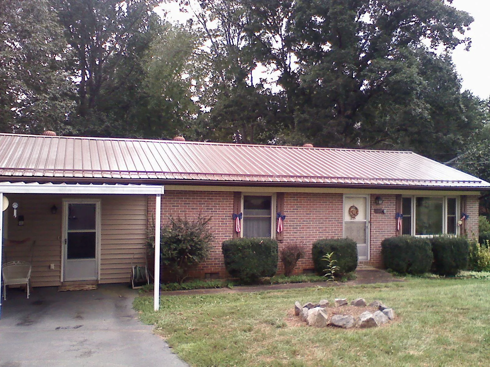Bronze metal roof and carport on a brick ranch home — Roof Repair work by our crew in Jamesville